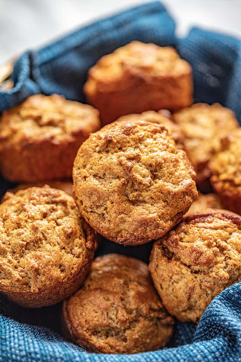 Bran muffins in a basket with a blue cloth.