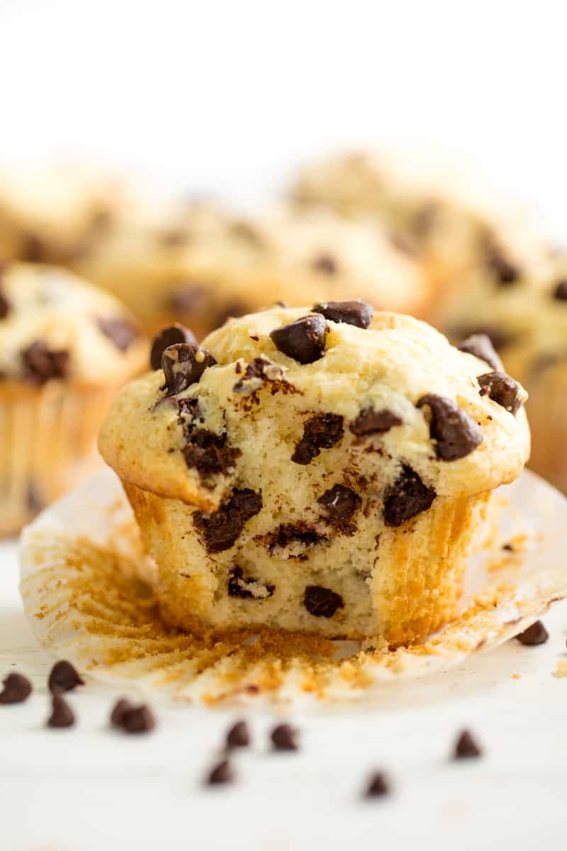 These Easy Chocolate Chip Muffins are just like mom used to make! The batter comes together in just minutes for an easy muffin that's perfect for breakfast or brunch.ย Chocolate Chip with the wrapper undone and a bite taken out of it.