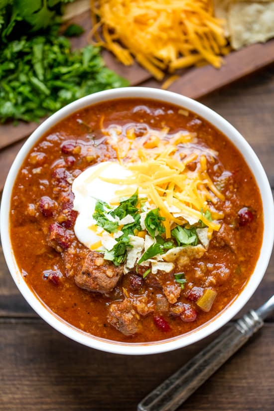 This Instant Pot Chili recipe is full of meaty goodness in this easy to make recipe that utilizes the hottest kitchen appliance trend: the electric pressure cooker.ย A bowl of Instant Pot Chili topped with sour cream, grated cheddar cheese and cilantro